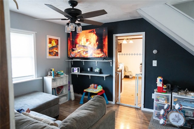 living room with wood-type flooring, plenty of natural light, vaulted ceiling, and ceiling fan