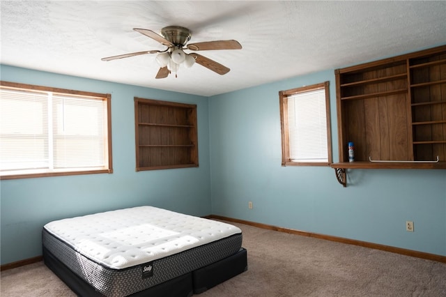 bedroom featuring ceiling fan, light carpet, and a textured ceiling