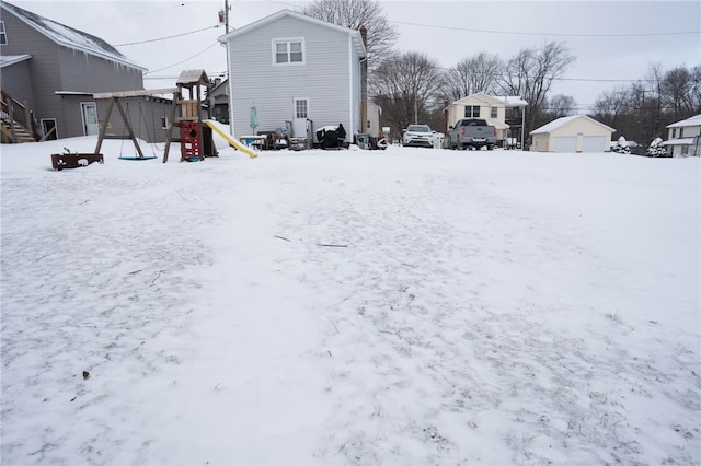 yard covered in snow with a playground