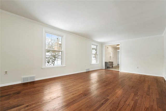 empty room featuring ornamental molding and dark wood-type flooring