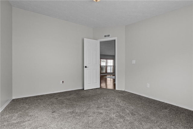 carpeted empty room with a textured ceiling