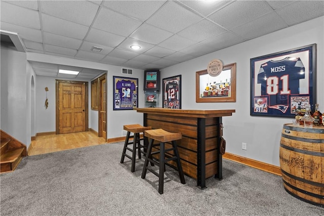 bar featuring carpet flooring and a drop ceiling