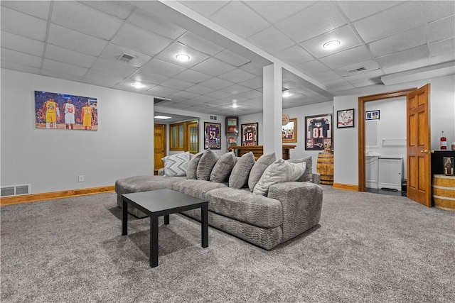 carpeted living room with a paneled ceiling