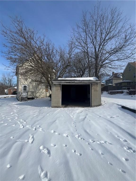 snow covered structure featuring a garage