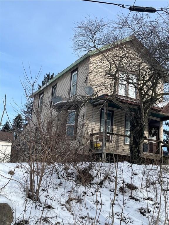 snow covered property featuring a porch