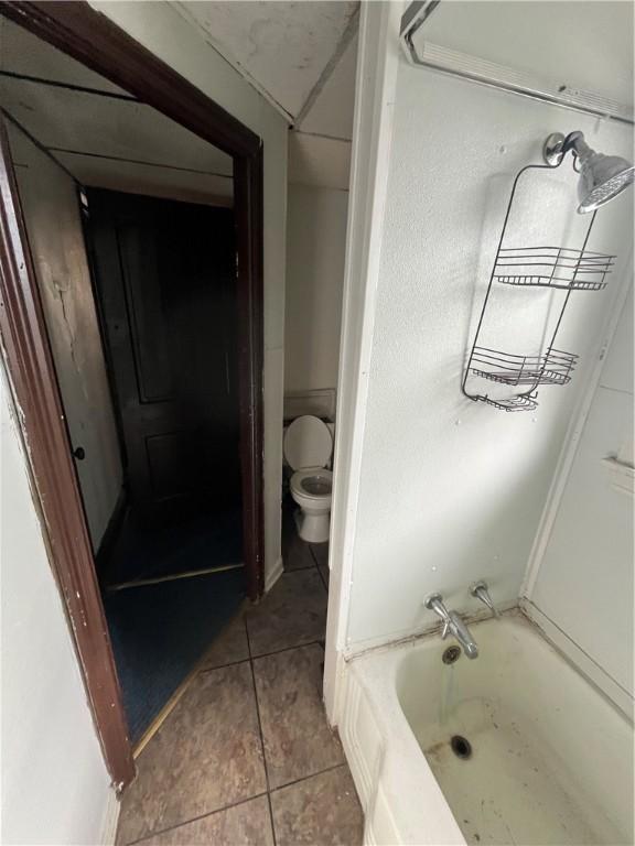 bathroom with toilet and tile patterned flooring