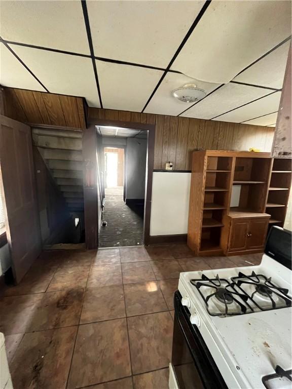 kitchen with white gas stove and wooden walls