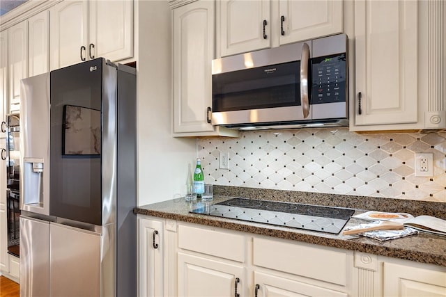 kitchen with white cabinets, dark stone counters, and black appliances