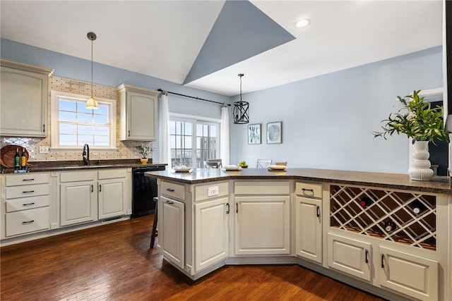 kitchen featuring decorative light fixtures, dishwasher, sink, cream cabinets, and dark wood-type flooring