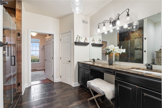 bathroom with walk in shower and vanity