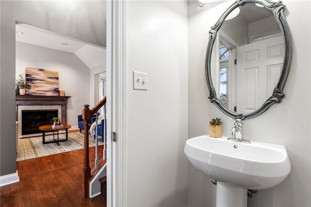 bathroom featuring sink, hardwood / wood-style floors, and lofted ceiling