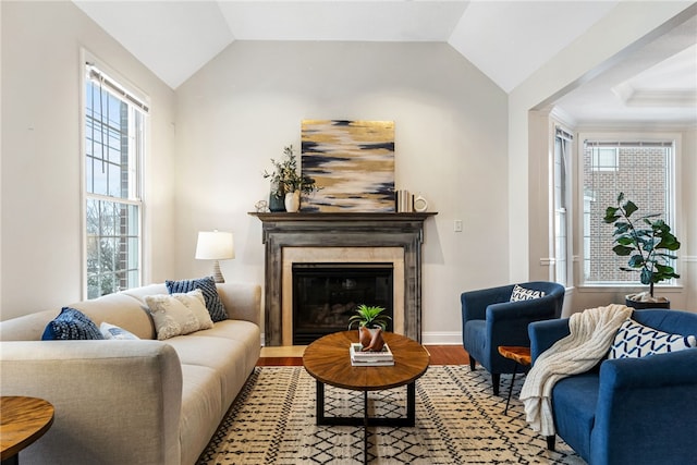 sitting room with plenty of natural light, hardwood / wood-style floors, and lofted ceiling