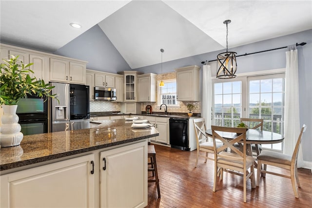 kitchen with pendant lighting, stainless steel appliances, dark wood-type flooring, and tasteful backsplash