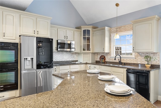 kitchen with vaulted ceiling, decorative light fixtures, sink, dark stone countertops, and black appliances