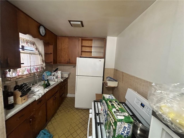 kitchen with tile walls, sink, and white appliances