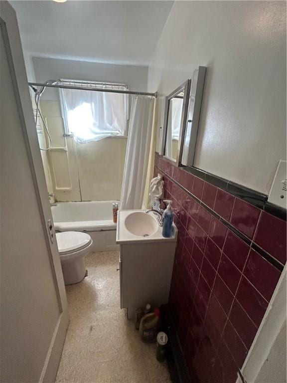 full bathroom featuring vanity, toilet, shower / tub combo, and tile walls