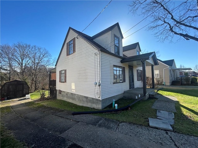 view of home's exterior with a yard and a storage unit