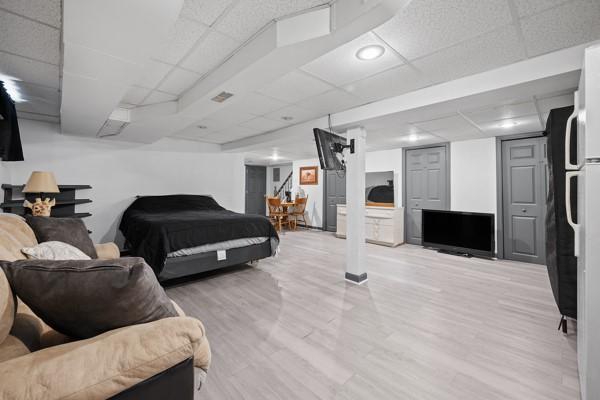 bedroom with a paneled ceiling and light hardwood / wood-style floors