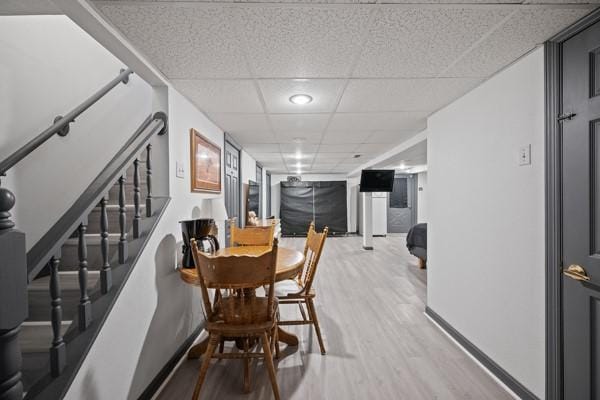 dining area featuring hardwood / wood-style floors and a paneled ceiling