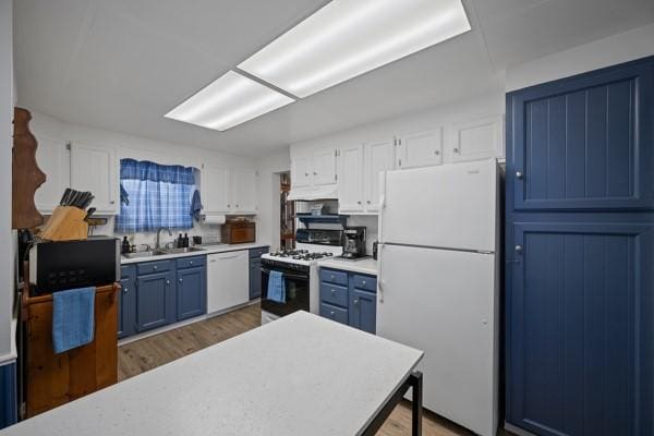 kitchen featuring blue cabinets, sink, white cabinetry, wood-type flooring, and white appliances