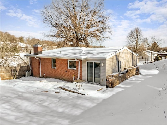 snow covered property with central AC unit