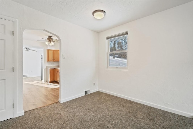 carpeted spare room with ceiling fan and a textured ceiling