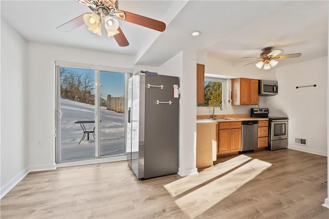 kitchen with sink, light hardwood / wood-style flooring, stainless steel appliances, and ceiling fan