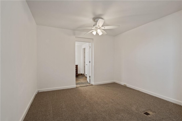 spare room with dark carpet and ceiling fan