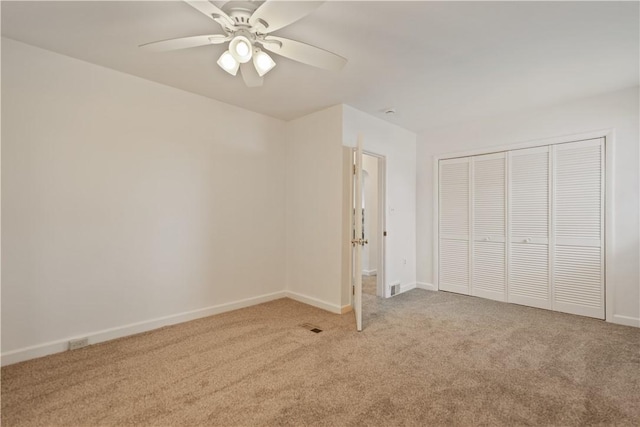 unfurnished bedroom with light carpet, ceiling fan, and a closet