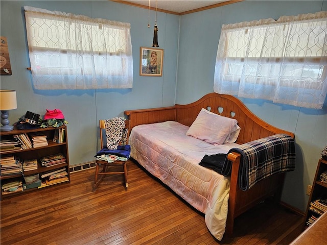 bedroom with hardwood / wood-style floors and crown molding