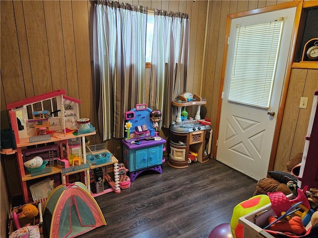 rec room with dark wood-type flooring and wood walls