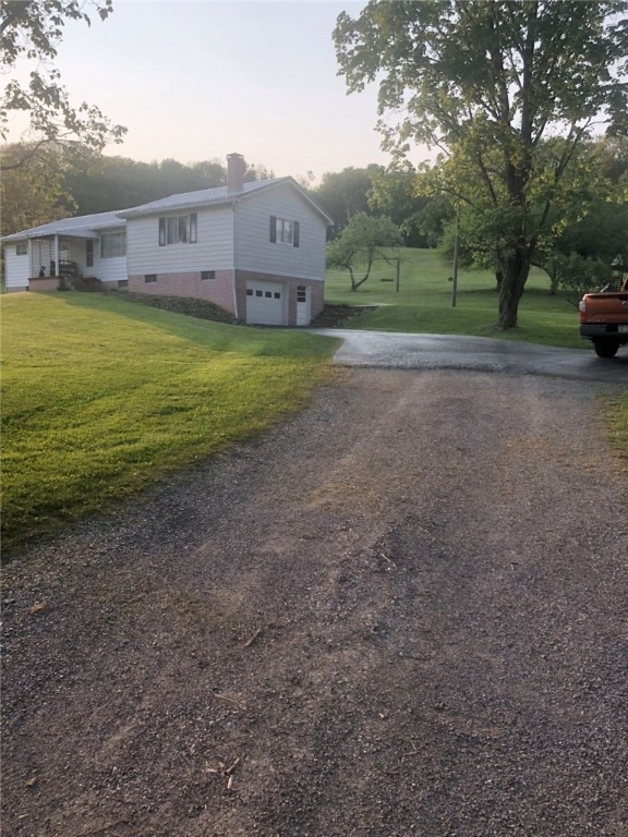 exterior space featuring a garage and a lawn