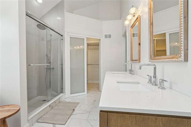 bathroom featuring marble finish floor, a sink, visible vents, and a stall shower