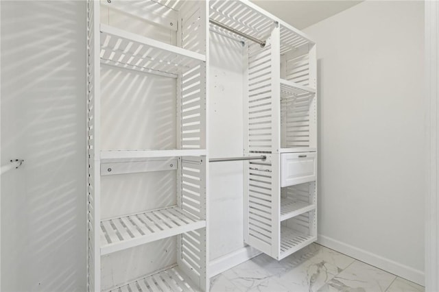 spacious closet featuring marble finish floor