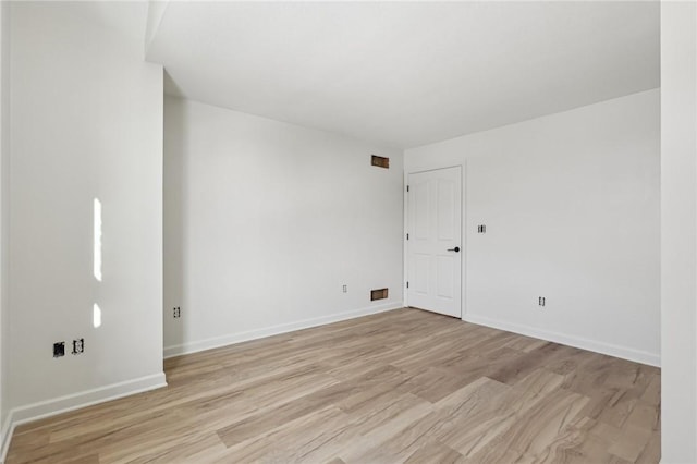 spare room featuring light wood-style floors and baseboards