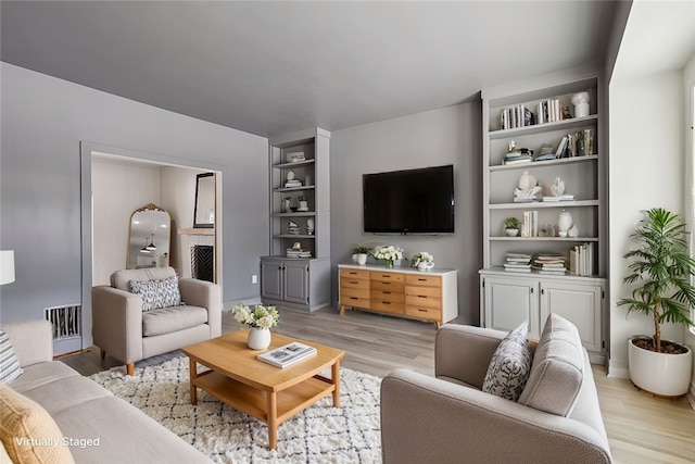 living room with light wood-style flooring and visible vents