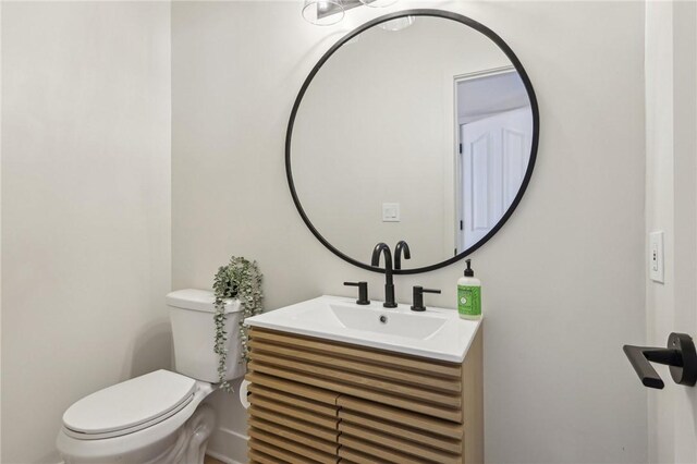 half bath featuring toilet and vanity