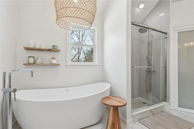 bathroom with baseboards, a freestanding bath, a chandelier, and a stall shower