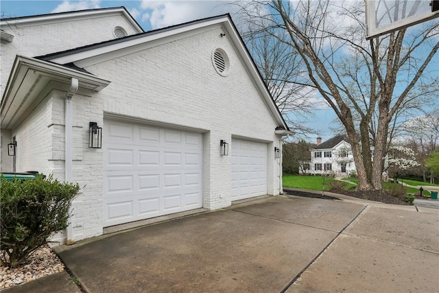 view of side of home featuring brick siding and concrete driveway