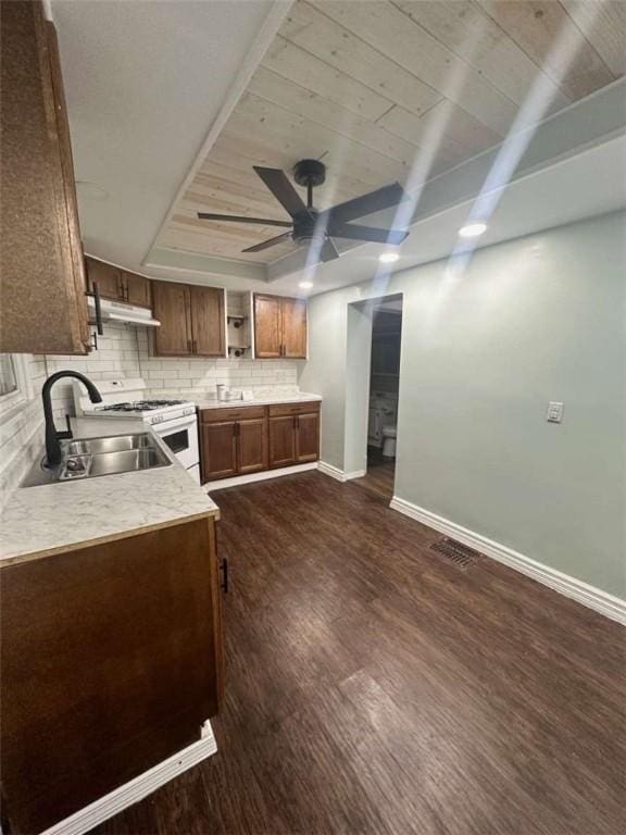 kitchen featuring sink, white gas range oven, ceiling fan, dark hardwood / wood-style floors, and wooden ceiling