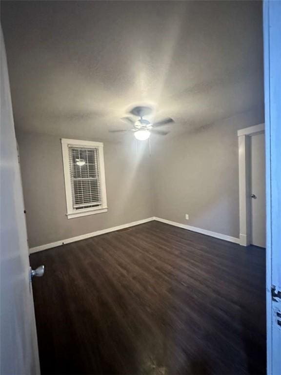 unfurnished room with dark wood-type flooring and ceiling fan