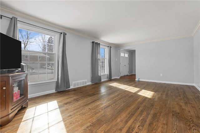 unfurnished living room featuring crown molding, plenty of natural light, and wood-type flooring