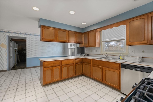 kitchen with tasteful backsplash, stainless steel dishwasher, kitchen peninsula, and sink