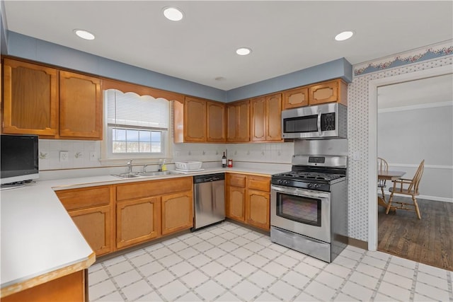 kitchen featuring stainless steel appliances, sink, and backsplash