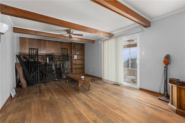 living area with hardwood / wood-style flooring, ornamental molding, ceiling fan, and beamed ceiling