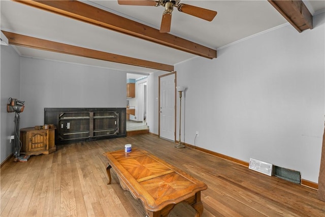 living room with ceiling fan, hardwood / wood-style flooring, and beamed ceiling