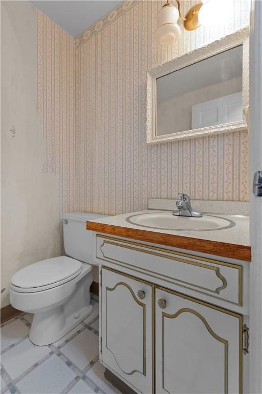 bathroom with tile patterned flooring, vanity, and toilet