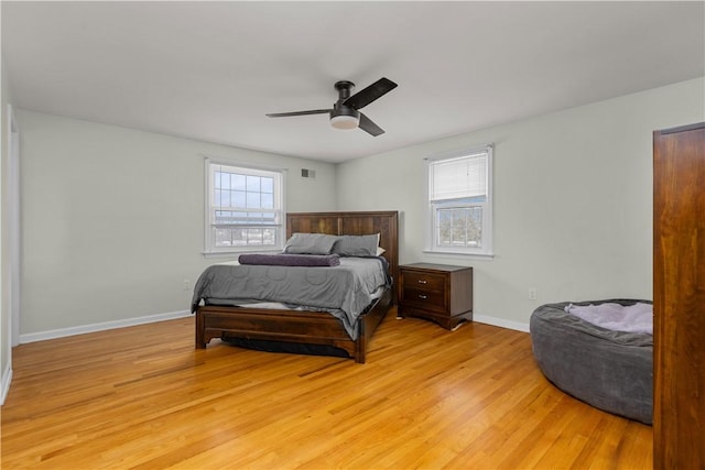 bedroom with multiple windows, ceiling fan, and light hardwood / wood-style flooring