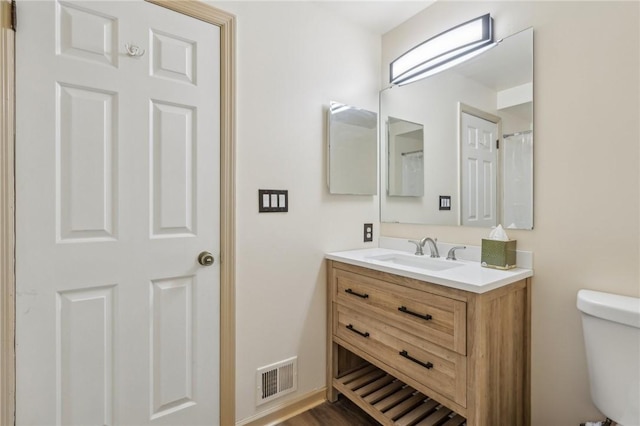 bathroom featuring vanity and toilet