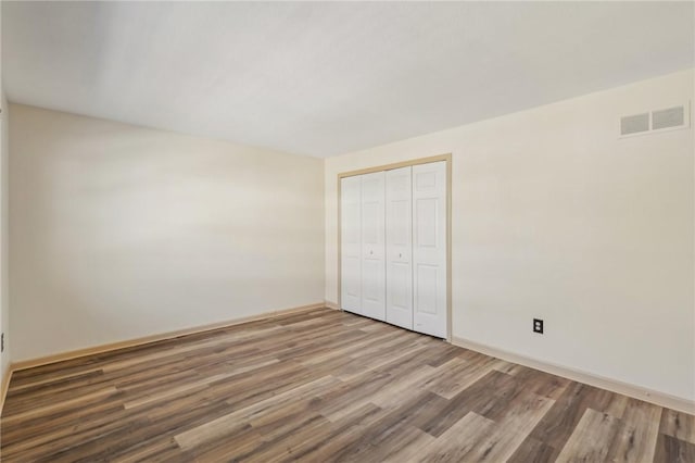 unfurnished bedroom featuring wood-type flooring and a closet